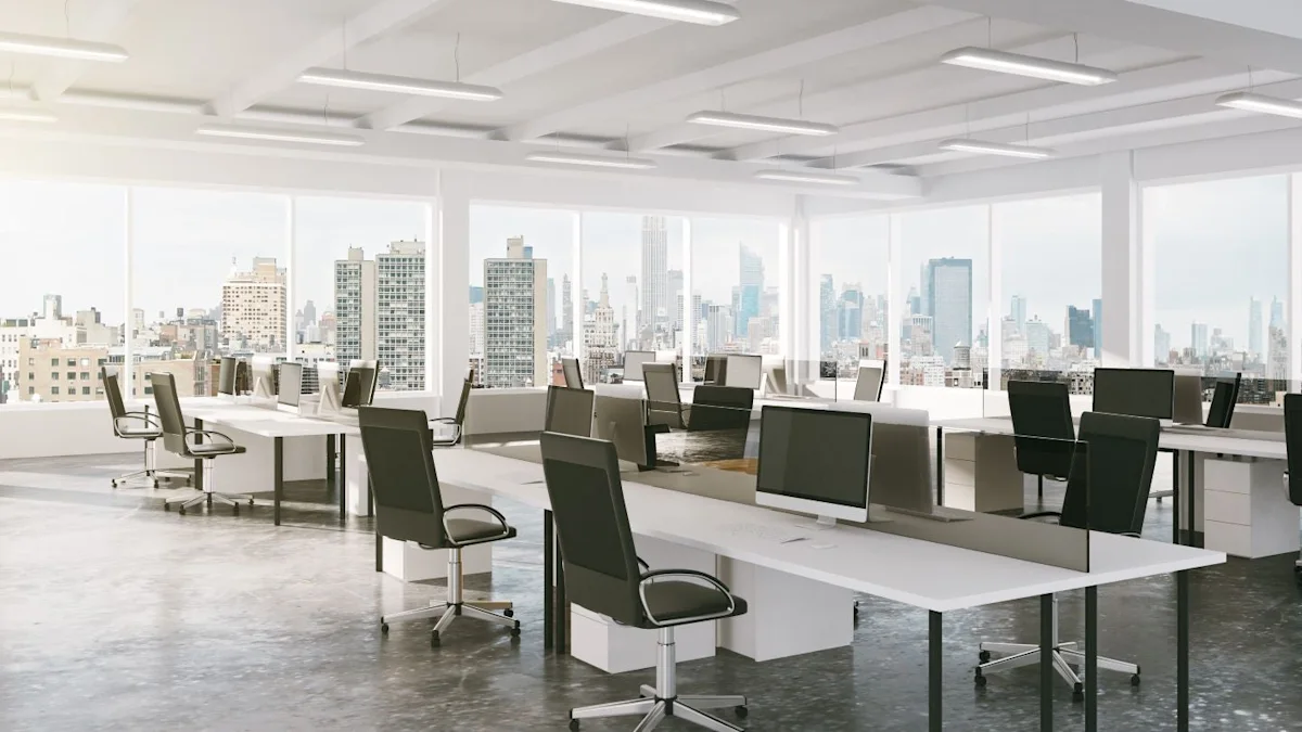Bright open-plan office with white desks, black chairs and large windows overlooking a city skyline